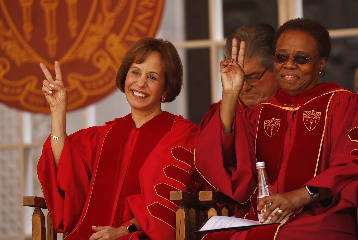 Dr. Carol L. Folt, left, gives the fight-on hand sign sitting next to Wanda Austin PhD, right, the former interim president of USC.
