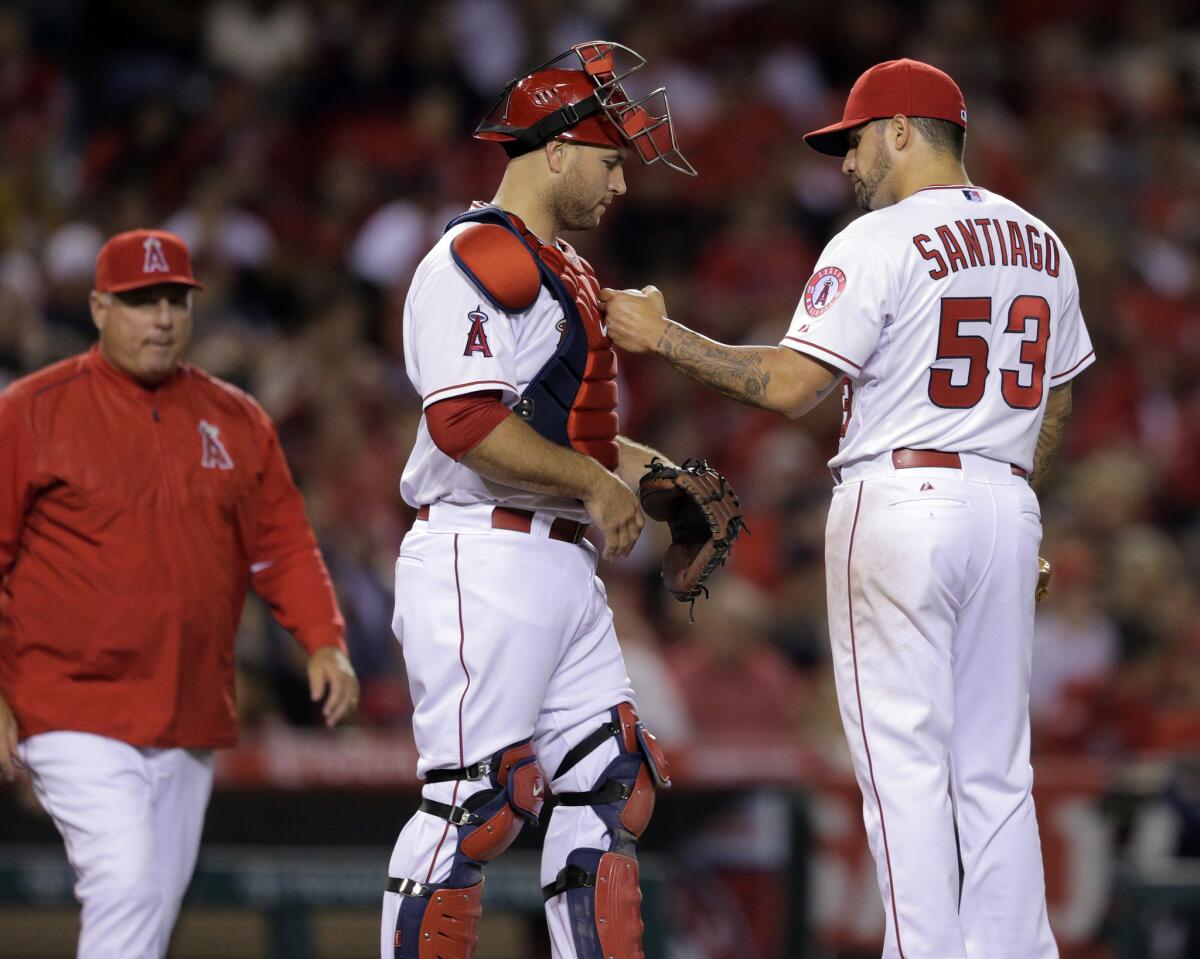 Angels Manager Mike Scioscia approaches the mound to pull pitcher Hector Santiago, who talks to catcher Chris Iannetta, on April 10, 2015.