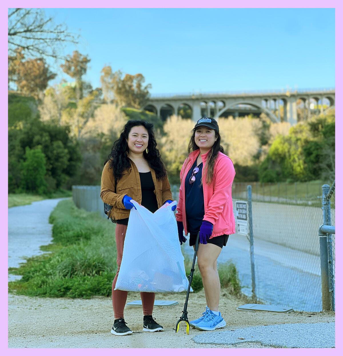 Kelly Villasor wears a tan jacket and holds a trash bag. Christy Villasor stands next to her in pink holding a trash picker.