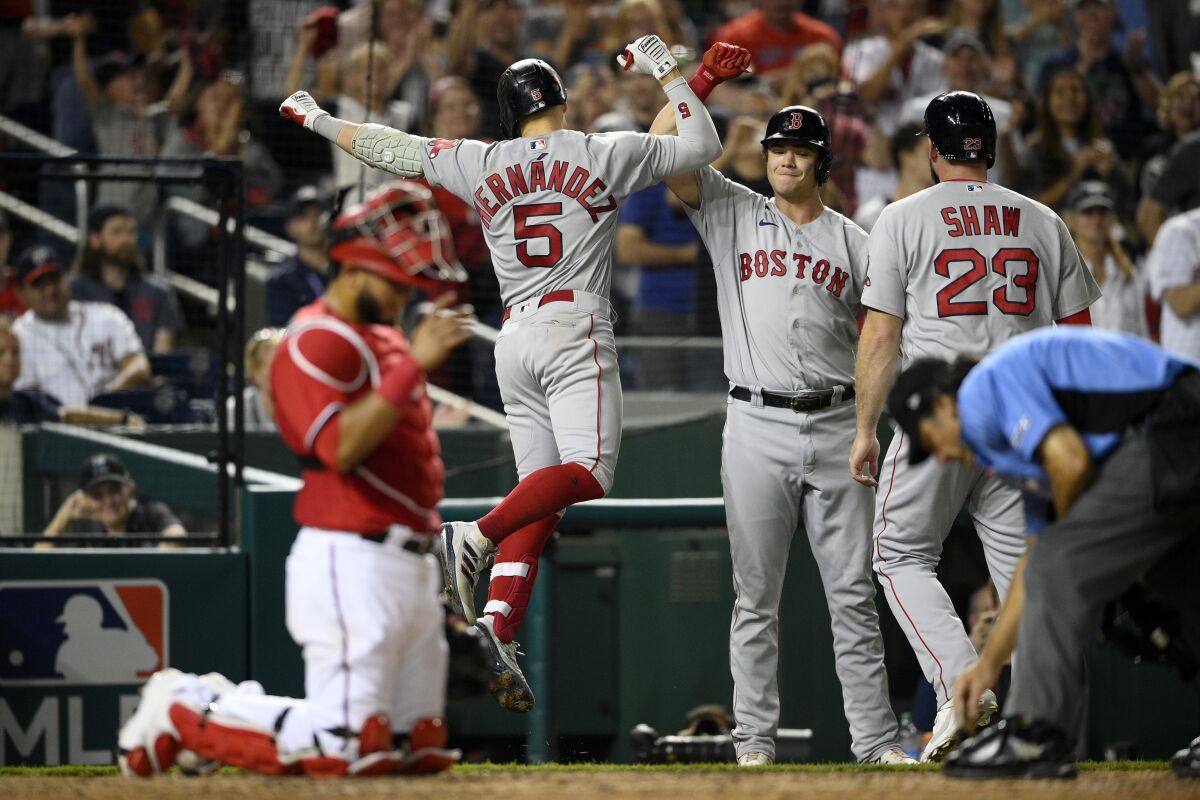 Boston Red Sox's Enrique Hernandez (5) celebrates his two-run home run with Bobby Dalbec, second from right, and Travis Shaw (23) during the ninth inning of a baseball game Saturday, Oct. 2, 2021, in Washington. Washington Nationals catcher Keibert Ruiz is at from left. The Red Sox won 5-3.(AP Photo/Nick Wass)
