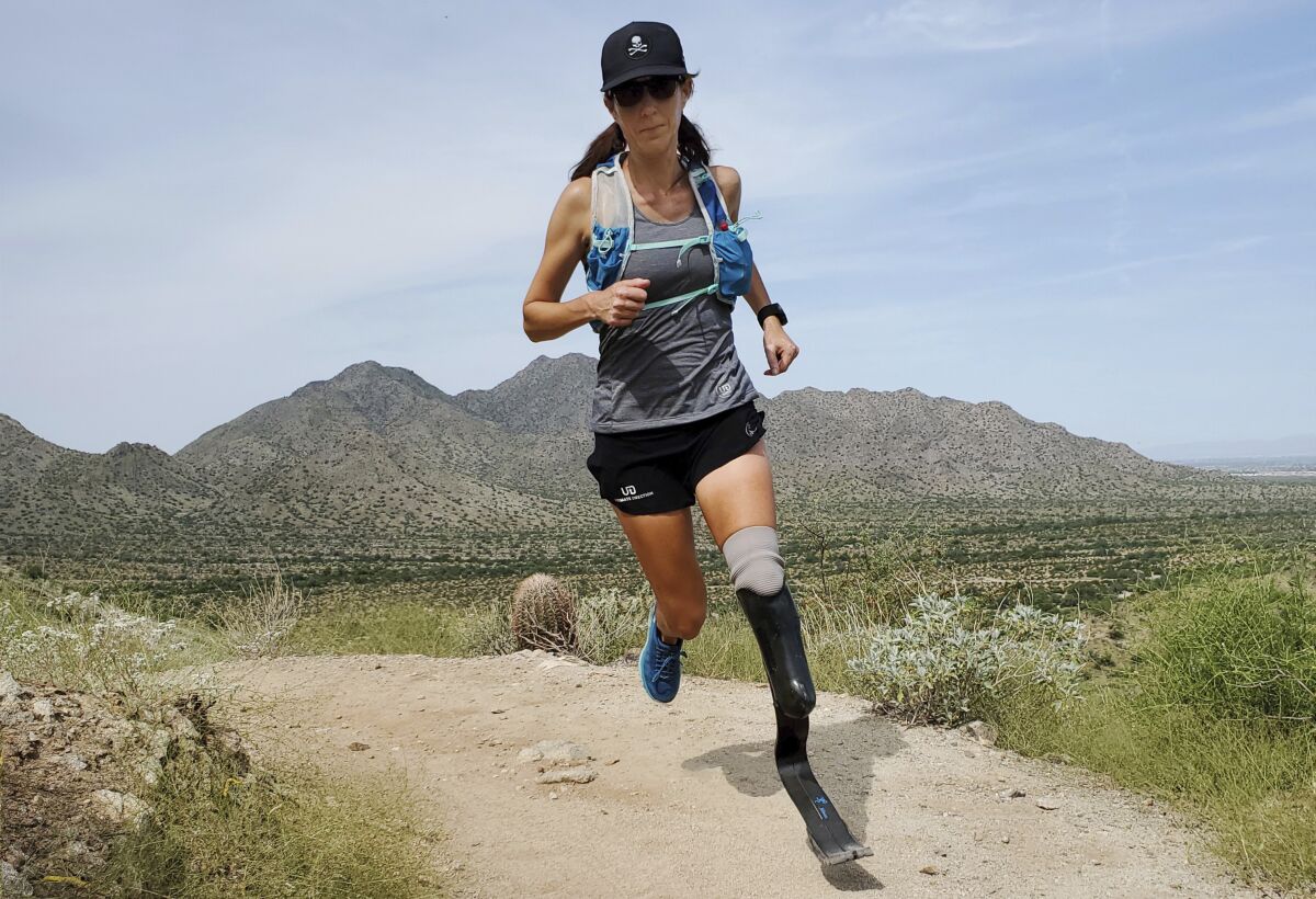 In this image provided by Edwin Broersma, marathoner Jacky Hunt-Broersma trains on Aug. 28, 2021 at San Tan Mountain Regional Park, in San Tan Valley, Az. Hunt-Broersma lost her left leg below the knee to a rare form of cancer, but she hasn't let that stop her and is trying to cover the classic 26.2-mile marathon distance at least 102 times in 102 days, which would set a new world record. The Boston Marathon on April 18 is expected to be No. 92 in her streak. (Edwin Broersma via AP)