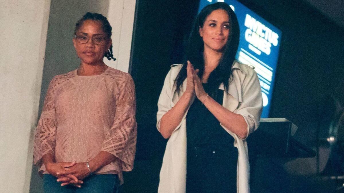 (FILES) In this file photo taken on October 1, 2017 Meghan Markle (C) and her mother Doria Ragland (L) watch the closing ceremonies for the Invictus Games in Toronto, Ontario. Mother of the bride - a social worker and a yoga instructor with dreadlocks and a nose ring, Meghan calls her a "free spirit". She met Thomas while working in television make-up. She has a master's degree in social work and ran the 2017 Los Angeles marathon. / AFP PHOTO / Geoff RobinsGEOFF ROBINS/AFP/Getty Images ** OUTS - ELSENT, FPG, CM - OUTS * NM, PH, VA if sourced by CT, LA or MoD **