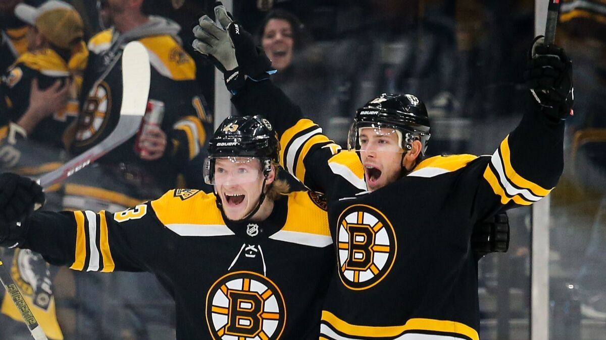 Boston Bruins' Charlie Coyle, right, and Danton Heinen celebrate with teammates after Coyle scored in overtime to beat the Columbus Blue Jackets in Game 1 of the Eastern Conference second round during the NHL playoffs on Thursday.