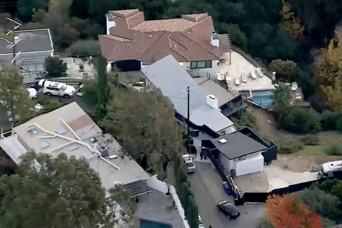 An aerial view of a neighborhood in the Hollywood Hills, centered on a house with black flat roof