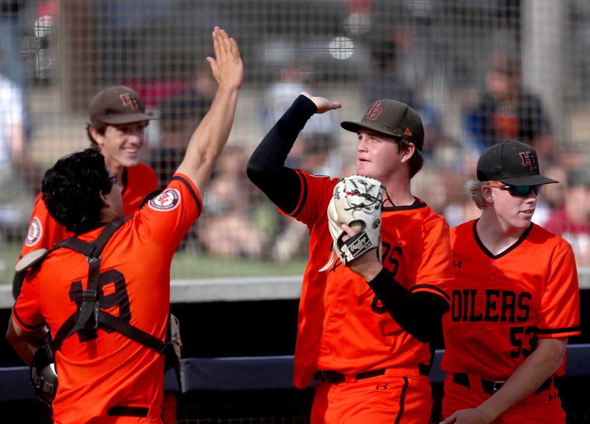 Huntington Beach starting pitcher Jack Smith is congratulated after getting out of a tough inning Thursday.