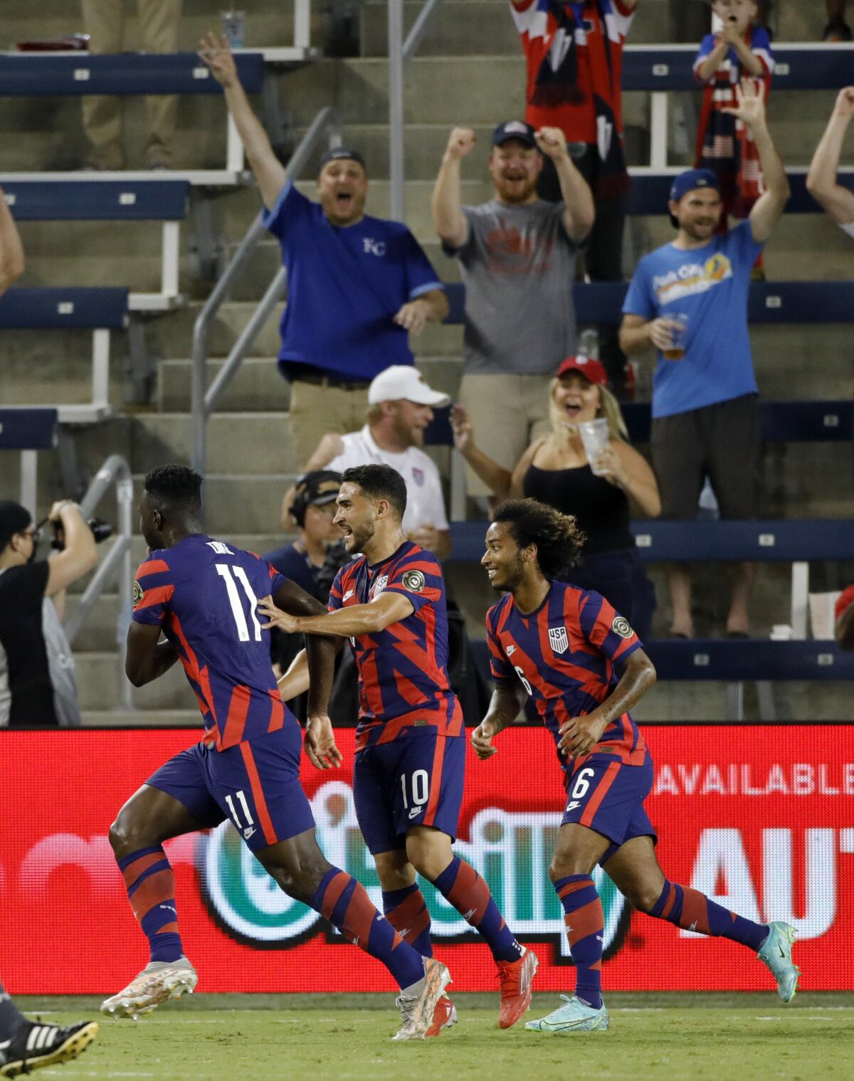 U.S. forward Daryl Dike (11) celebrates with Cristian Roldan (10) and Gianluca Busio (6) after scoring a goal in the first half of the team's CONCACAF Gold Cup soccer match against Martinique in Kansas City, Kan., Thursday, July 15, 2021. (AP Photo/Colin E. Braley)