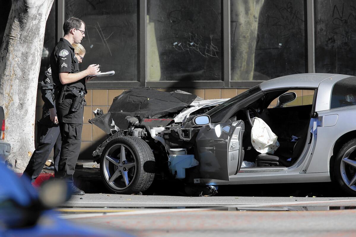 Officers investigate the scene of the LAPD's fatal shooting of an unarmed driver who crashed his car downtown after a high-speed chase.