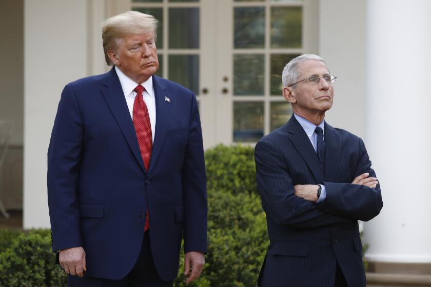 President Donald Trump and Dr. Anthony Fauci, right, director of the National Institute of Allergy and Infectious Diseases, attend a coronavirus task force briefing in the Rose Garden of the White House, Sunday, March 29, 2020, in Washington. (AP Photo/Patrick Semansky)