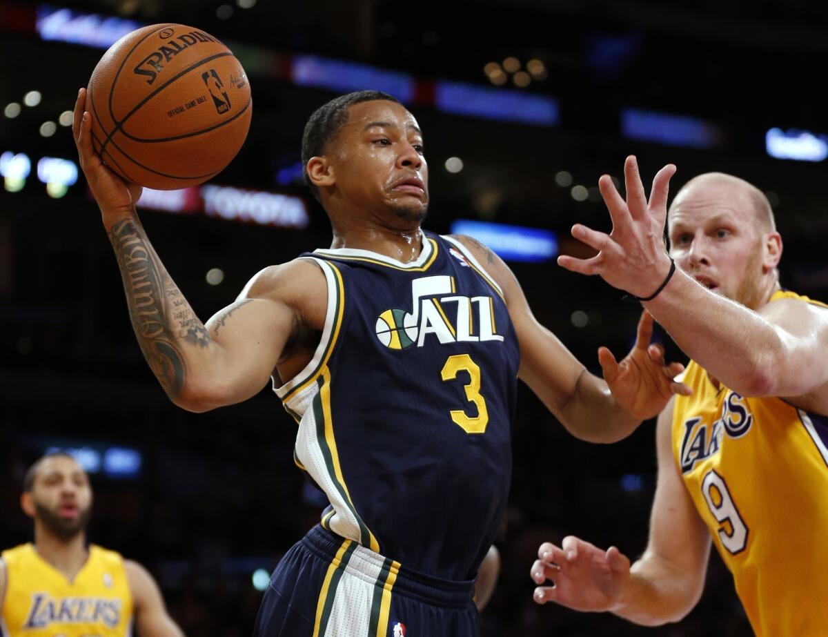 Utah's Trey Burke passes the ball in front of Chris Kaman during the Jazz's 96-79 victory over the Lakers at Staples Center.