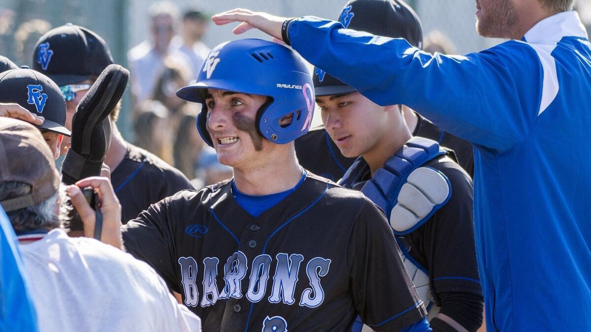 Fountain Valley High's Shea Adame is congratulated by the dugout after scoring on a Conrad Villafuerte single in the fifth inning at Canyon on Thursday.