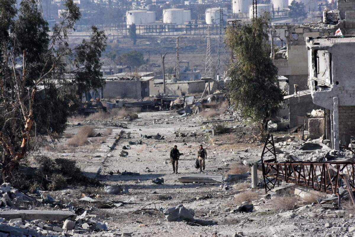 Syrian pro-government forces patrol an Aleppo district Dec. 12 after troops retook the area from rebel fighters.