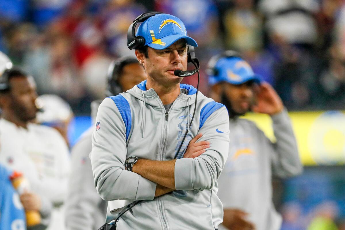 Chargers coach Brandon Staley walks the sideline with his arms crossed during a game.