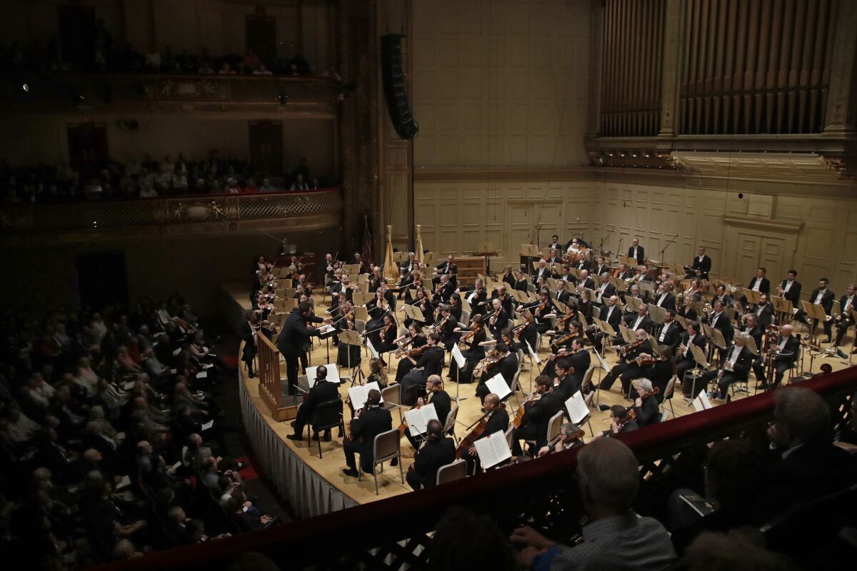 FILE — Andris Nelsons conducts a joint concert of the Boston Symphony Orchestra and Germany's visiting Leipzig Gewandhaus Orchestra, Thursday, Oct. 31, 2019, at Symphony Hall in Boston. The BSO has canceled its European tour that had been scheduled for next month because of an increase in positive coronavirus cases among orchestra members. Despite health and safety protocols the orchestra said in a statement Monday, April 11, 2022 that 31 onstage musicians were affected after recent performances. (AP Photo/Elise Amendola, File)