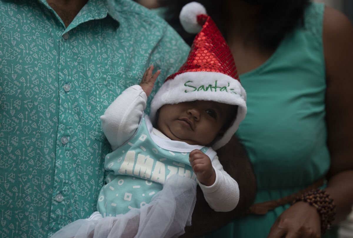 A baby is dressed in a Santa hat at a shopping mall in Johannesburg, South Africa