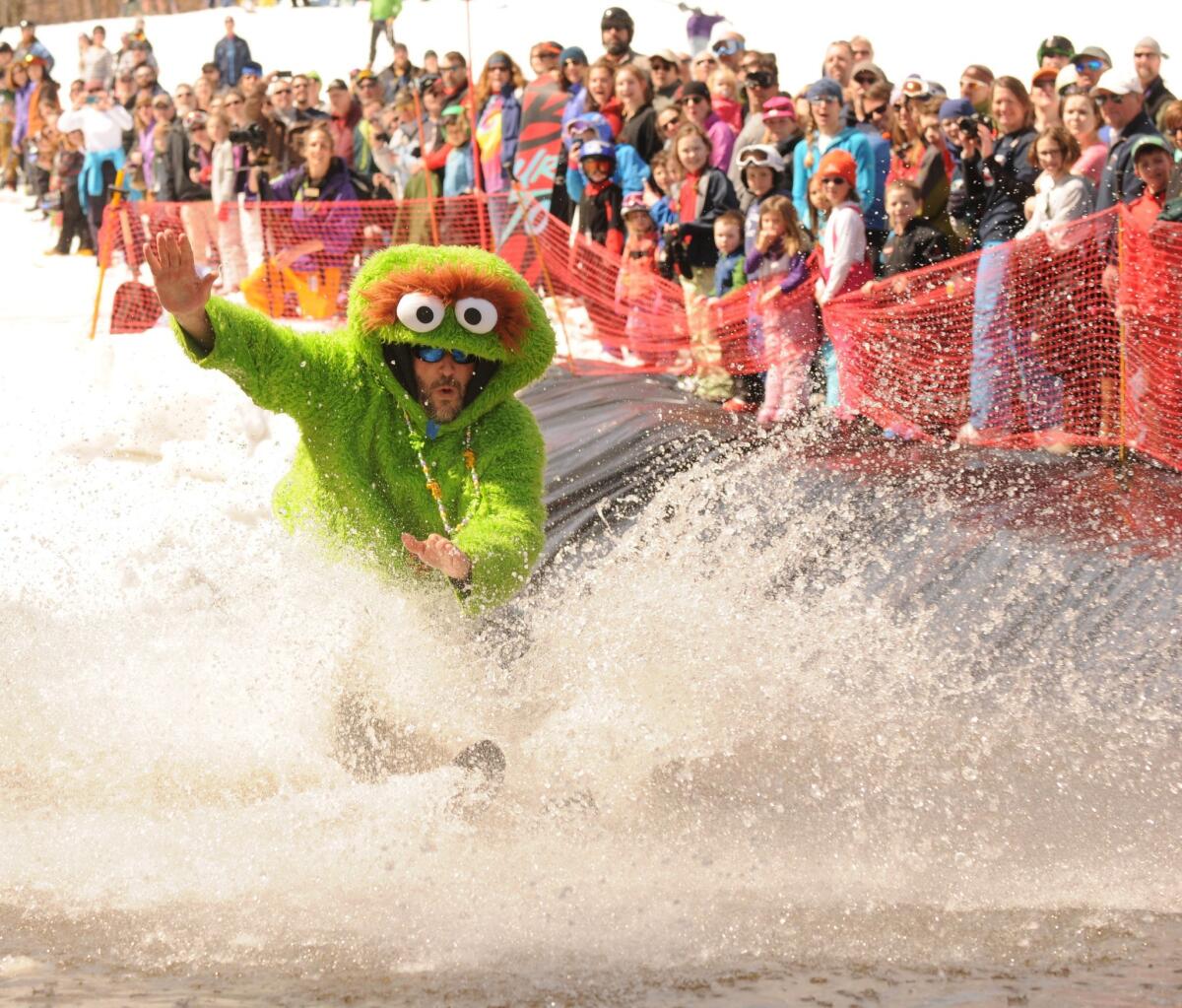 A pond skimmer dressed as Oscar the Grouch makes a splash while attempting to ski across a man-made pond at the Whiteface Mountain Ski Center in Wilmington, N.Y., in mid-April.