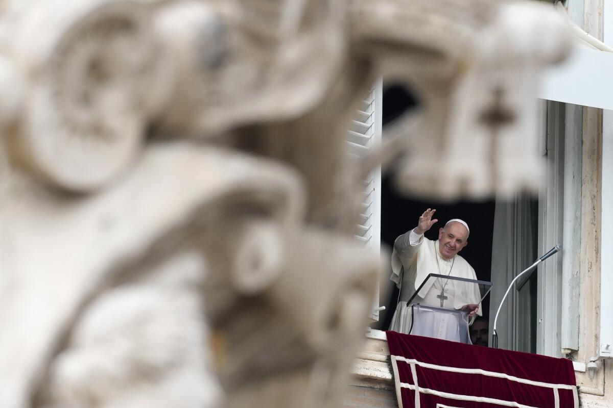Pope Francis waves as he arrives for the Angelus noon prayer from the window of his studio overlooking St.Peter's Square, at the Vatican, Sunday, Oct. 3, 2021. (AP Photo/Alessandra Tarantino)