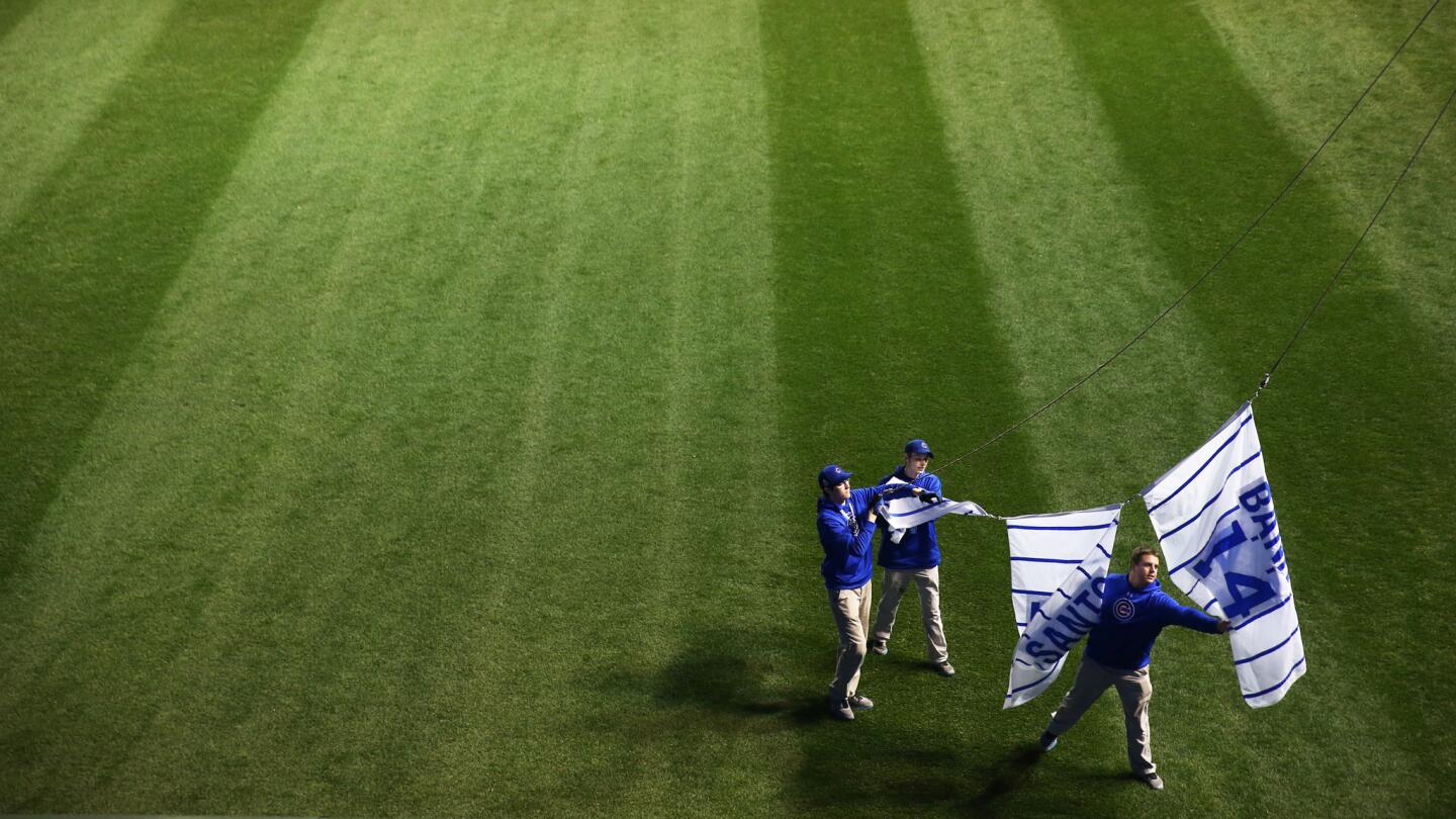 Workers take down players banners after the Cleveland Indians win 7-2 over the Chicago Cubs.