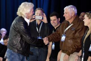 FILE - Sir Richard Branson, left, shakes hands with record breaking aviator Dick Rutan 