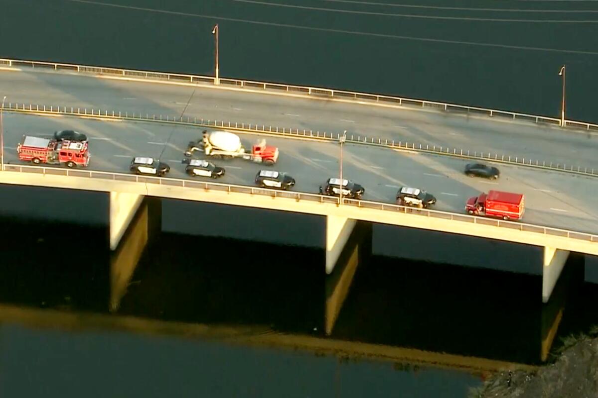 An aerial view of emergency vehicles on a bridge over water.