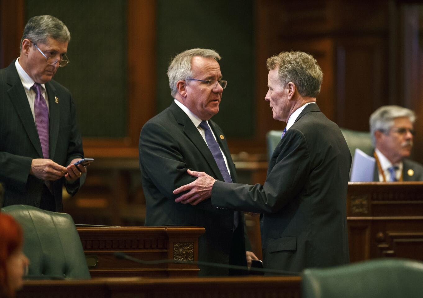 Illinois State Rep. Steve Andersson, R-Geneva, center, shakes hands with Illinois Speaker of the House Michael Madigan, D-Chicago, right, after the Illinois House voted to override Gov. Rauner's veto and pass a budget for the first time in two years during an overtime session at the Illinois State Capitol, Thursday, July 6, 2017, in Springfield, Ill.