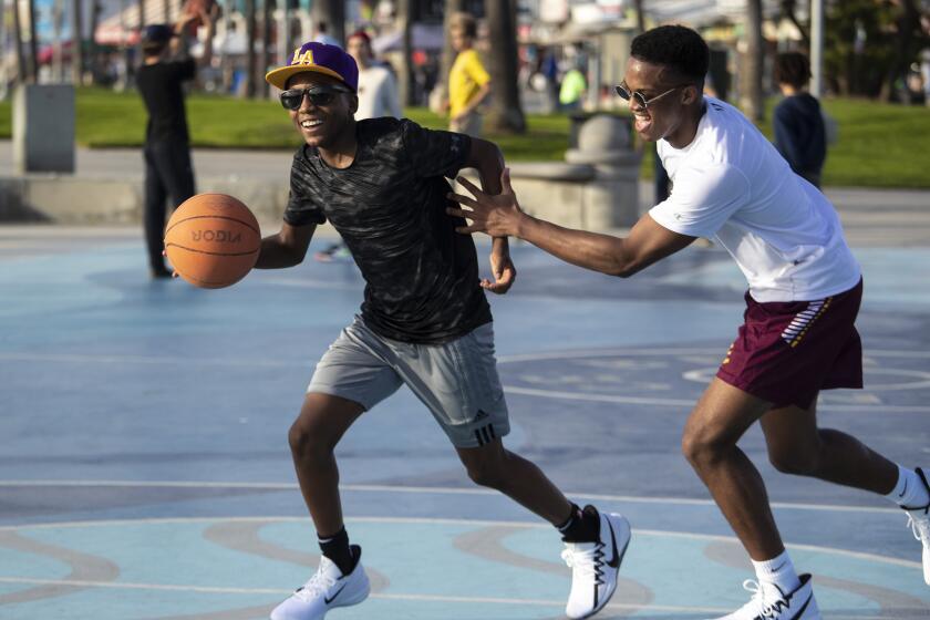 VENICE, CALIF. -- FRIDAY, JANUARY 31, 2020: Marcus Bowen, 13, left, drives on brother Dante Bowen, 16, right, on the public courts during pick-up games in Venice, Calif., on Jan. 31, 2020. (Brian van der Brug / Los Angeles Times)