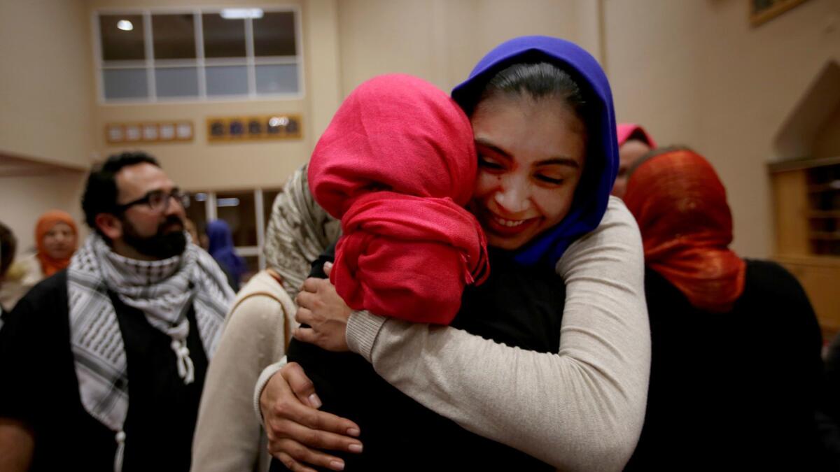 Rida Hamida, left, the main organizer of #IStandWithHijabis, gets a hug from Daisy Campos of Santa Ana at the Islamic Society of Orange County in Garden Grove.