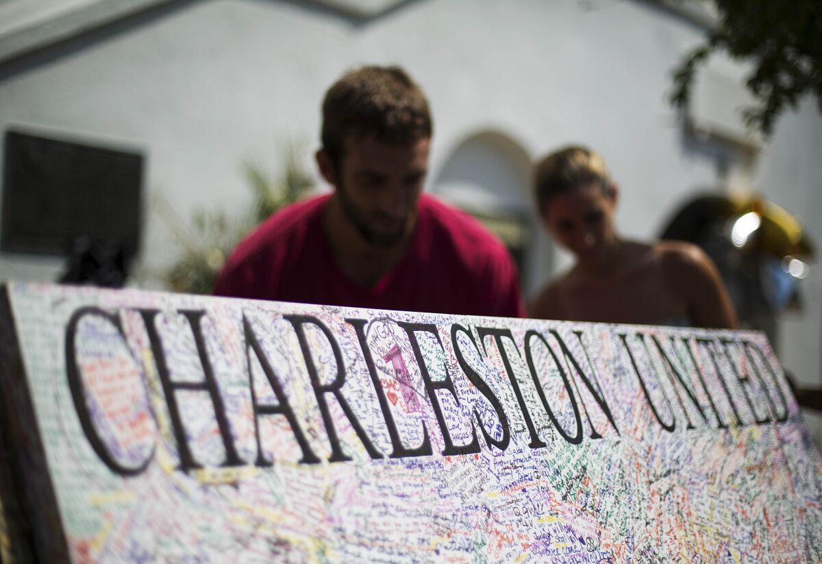 A message board stands at a sidewalk memorial as visitors write notes in memory of the shooting victims in front of Emanuel AME Church on June 22 in Charleston, S.C.