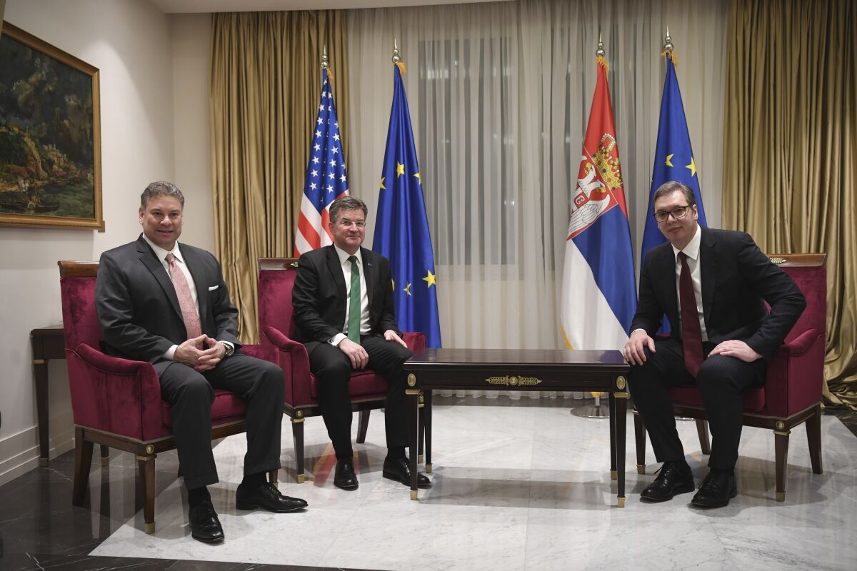 In this photo provided by the Serbian Presidential Press Service, Serbian President Aleksandar Vucic, right, speaks with Miroslav Lajcak, the EU's special envoy for the talks, center, and U.S. Deputy Assistant Secretary Gabriel Escobar in Belgrade, Serbia, Wednesday, Feb. 2, 2022. Envoys from the European Union and the United States on Wednesday urged Kosovo and Serbia to make concrete progress in EU-brokered negotiations aimed at resolving a long-running dispute that remains a source of tensions in the volatile Balkans. (Serbian Presidential Press Service via AP)