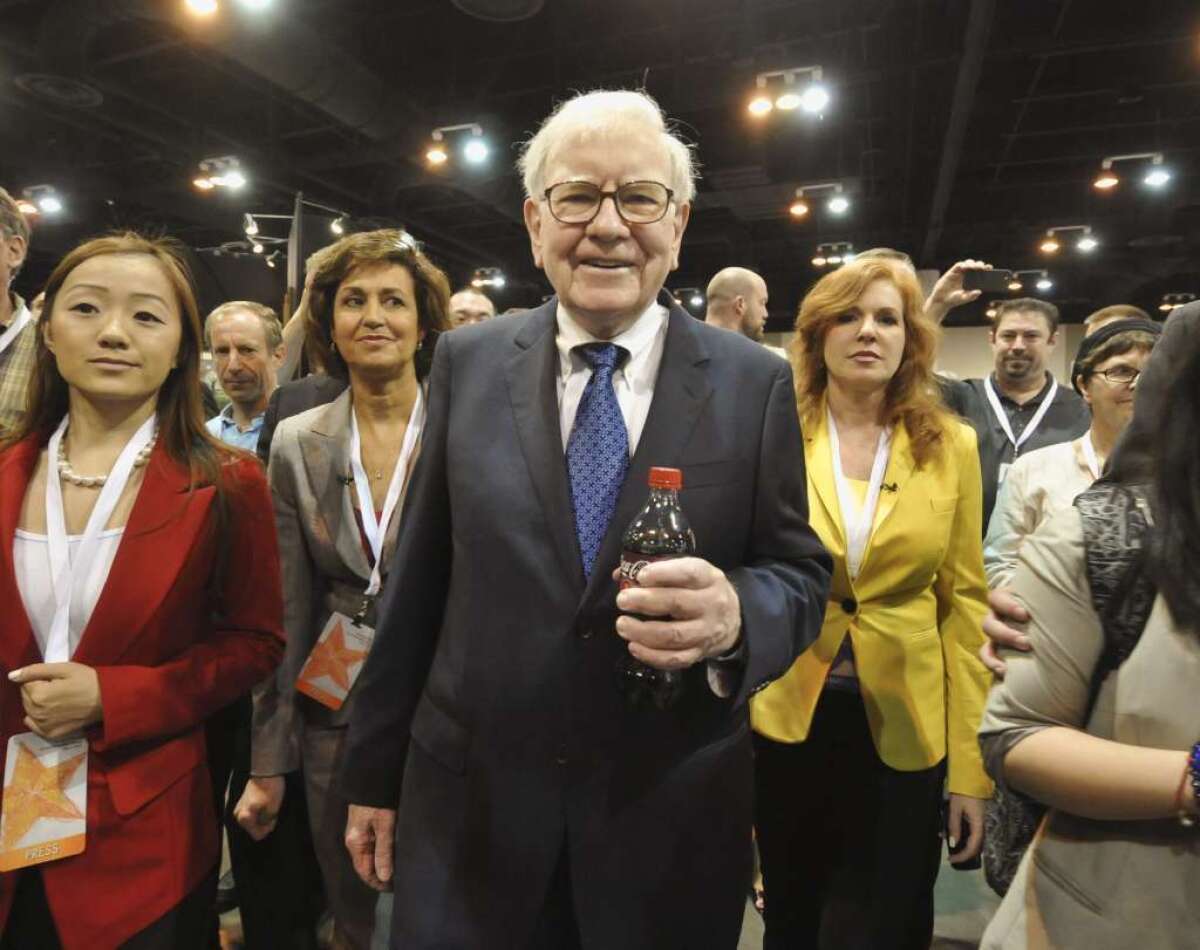 Warren Buffett, touring the exhibit floor at a 2012 Omaha shareholders meeting, makes the case for expanding economic opportunities for women.