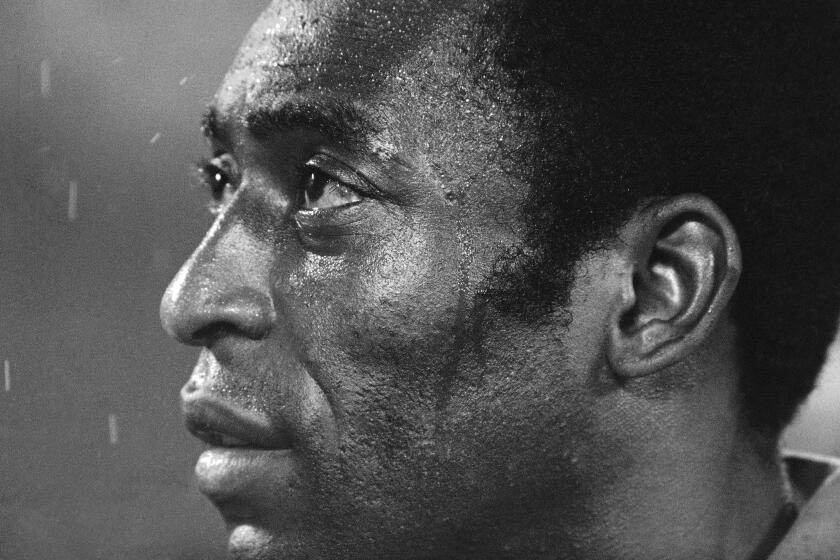 FILE - Soccer star Pele, of the New York Cosmos, listens to the star-spangled banner prior to a playoff game between the Cosmos and the Rochester Lancers in Giants Stadium, East Rutherford, New Jersey, Aug. 24, 1977. Pelé, the Brazilian king of soccer who won a record three World Cups and became one of the most commanding sports figures of the last century, died in Sao Paulo on Thursday, Dec. 29, 2022. He was 82. (AP Photo/Ray Stubblebine, File)