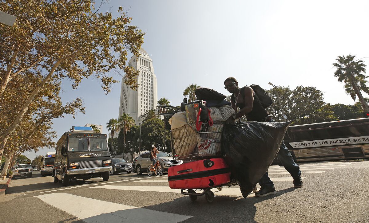 A man moves his belongings back to the sidewalk on 1st Street in downtown Los Angeles after a cleanup in October.