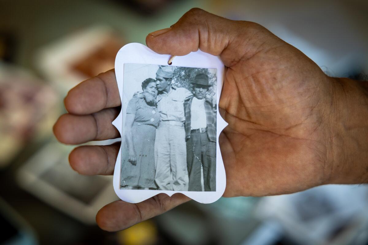 Larry Herrera-Cabrera, shown holding a photo of his father