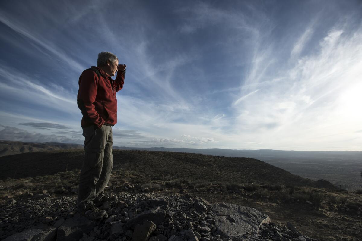 Bill Pape looks to the south across the Mexican border from a mesa near his home in Jacumba Hot Springs, Calif.