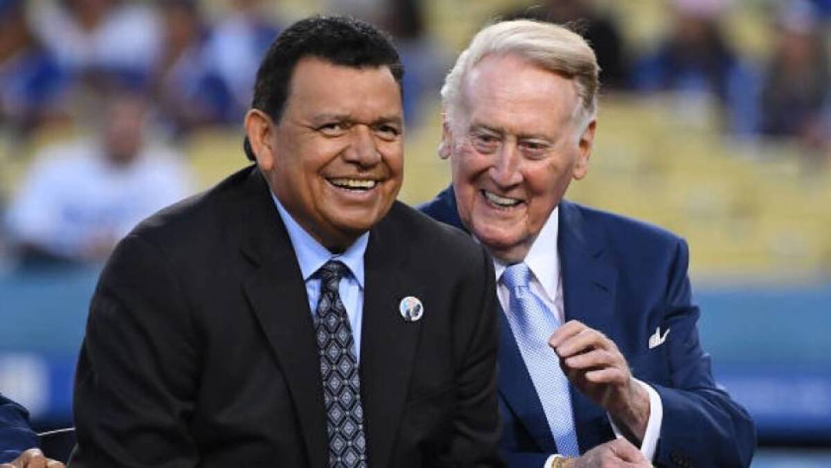 La leyenda de los Dodgers Fernando Valenzuela, a la izquierda, bromea con el retirado locutor del equipo, Vin Scully, durante una ceremonia previa al partido en el Dodger Stadium en septiembre.