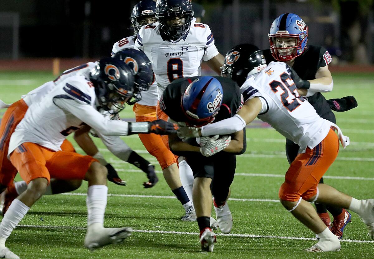 Serra running back Kai Honda lowers his head and braces for impact from a pack of Chaminade defenders.