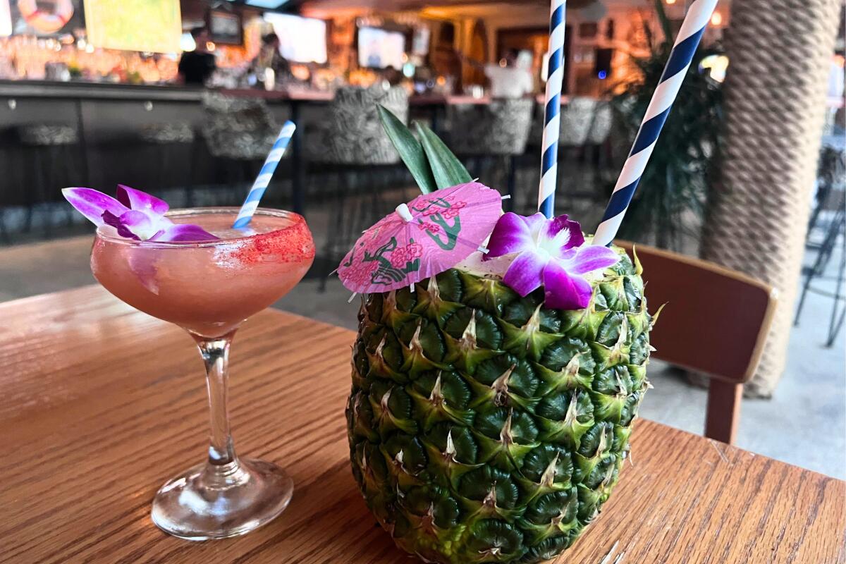 A Painkiller cocktail for two served in a pineapple and a guava daiquiri from Gin Rummy bar.