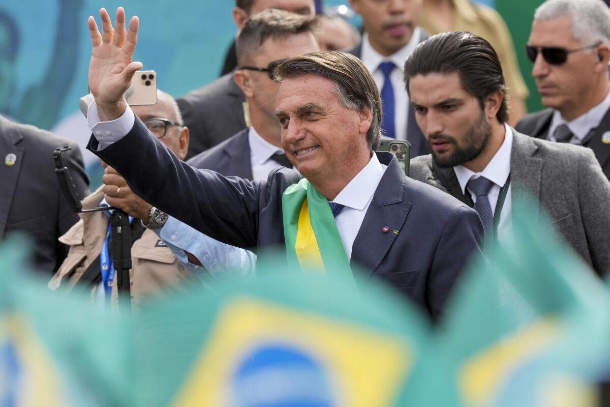 Brazil's President Jair Bolsonaro waves upon his arrival to preside over a military parade commemorating the bicentennial of the country's independence from Portugal in Brasilia, Brazil, Wednesday, Sept. 7, 2022. (AP Photo/Eraldo Peres)