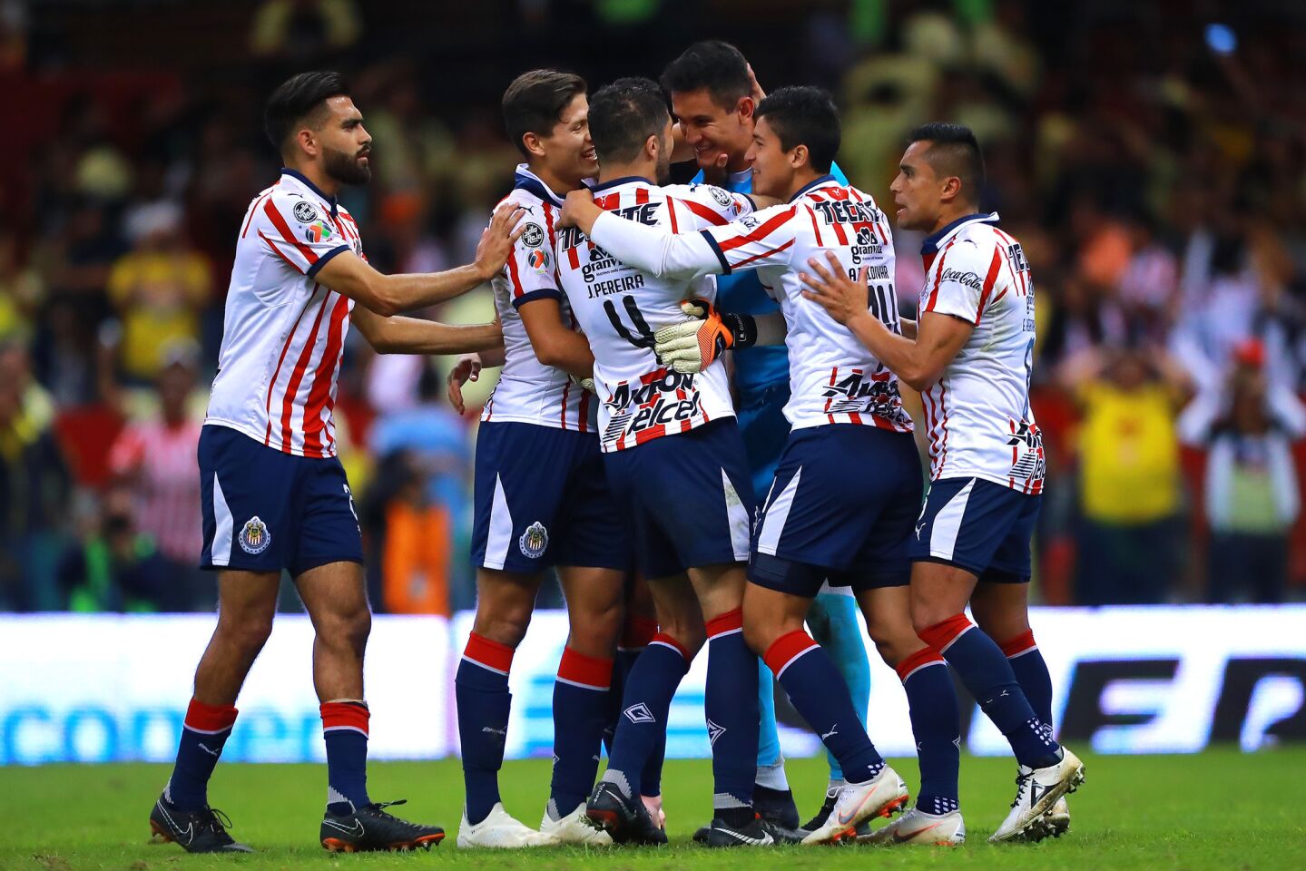 Raul Gudiño #1 of Chivas celebrates with teammates after stopping a penalty kick during the 11th round match between America and Chivas as part of the Torneo Apertura 2018 Liga MX at Azteca Stadium on September 30, 2018 in Mexico City, Mexico.