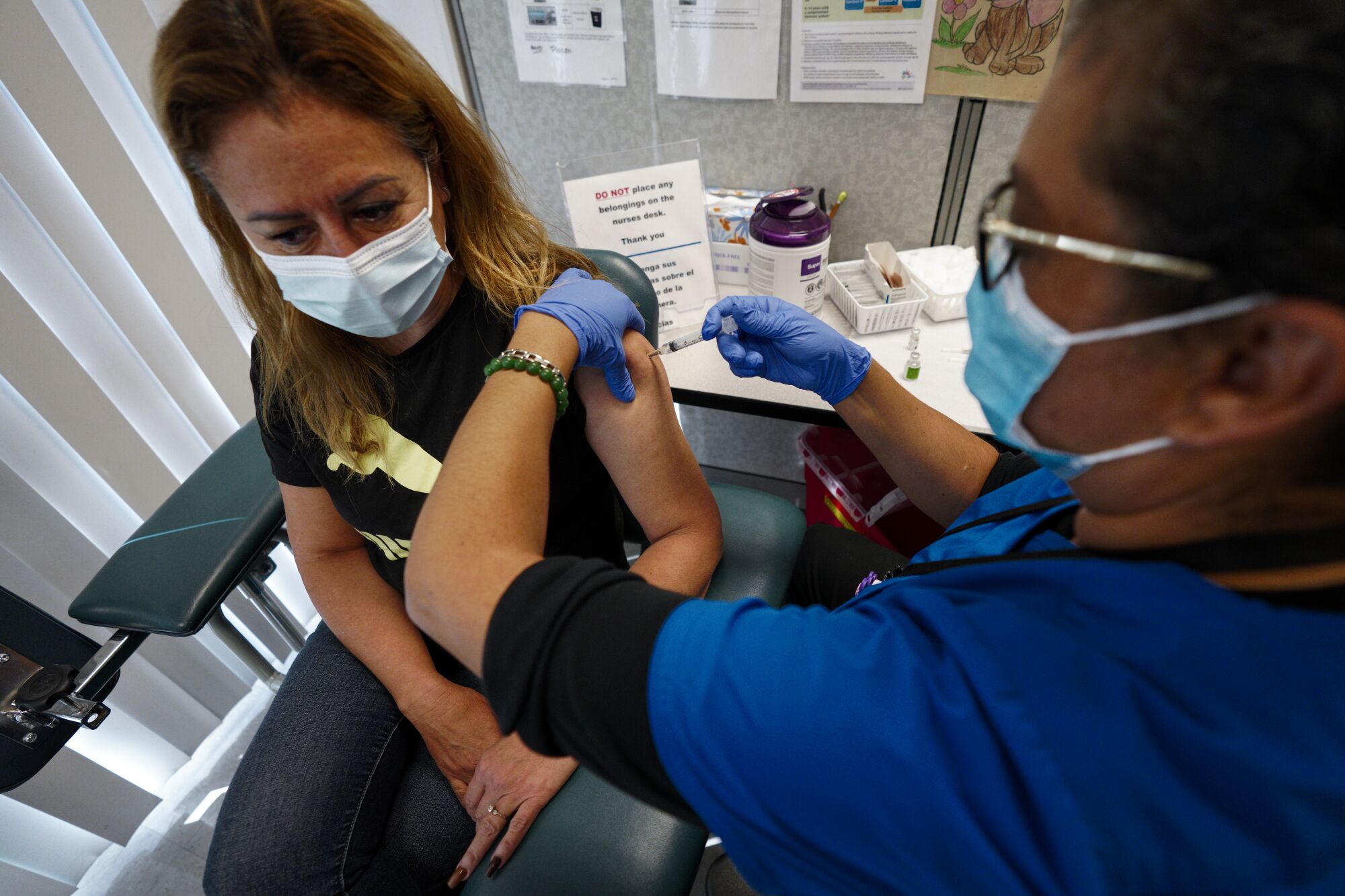 Angelica Soto from San Ysidro gets a flu shot from Carmen Gomez.