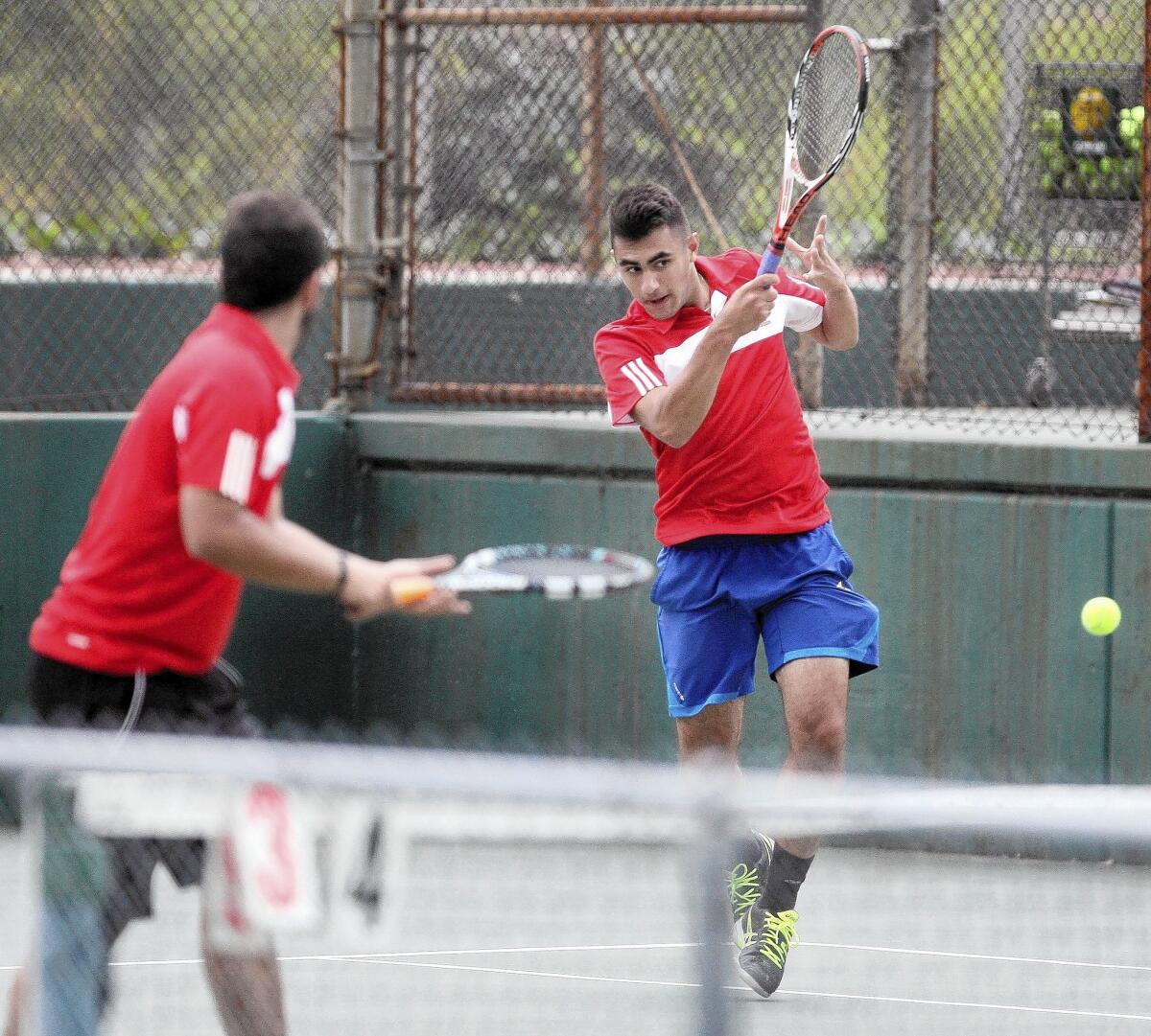Glendale's Arin Meserkhani returns the ball as doubles partner Michael Akopians watches during the Pacific League tennis finals at Pasadena High on Wednesday, May 7, 2014.