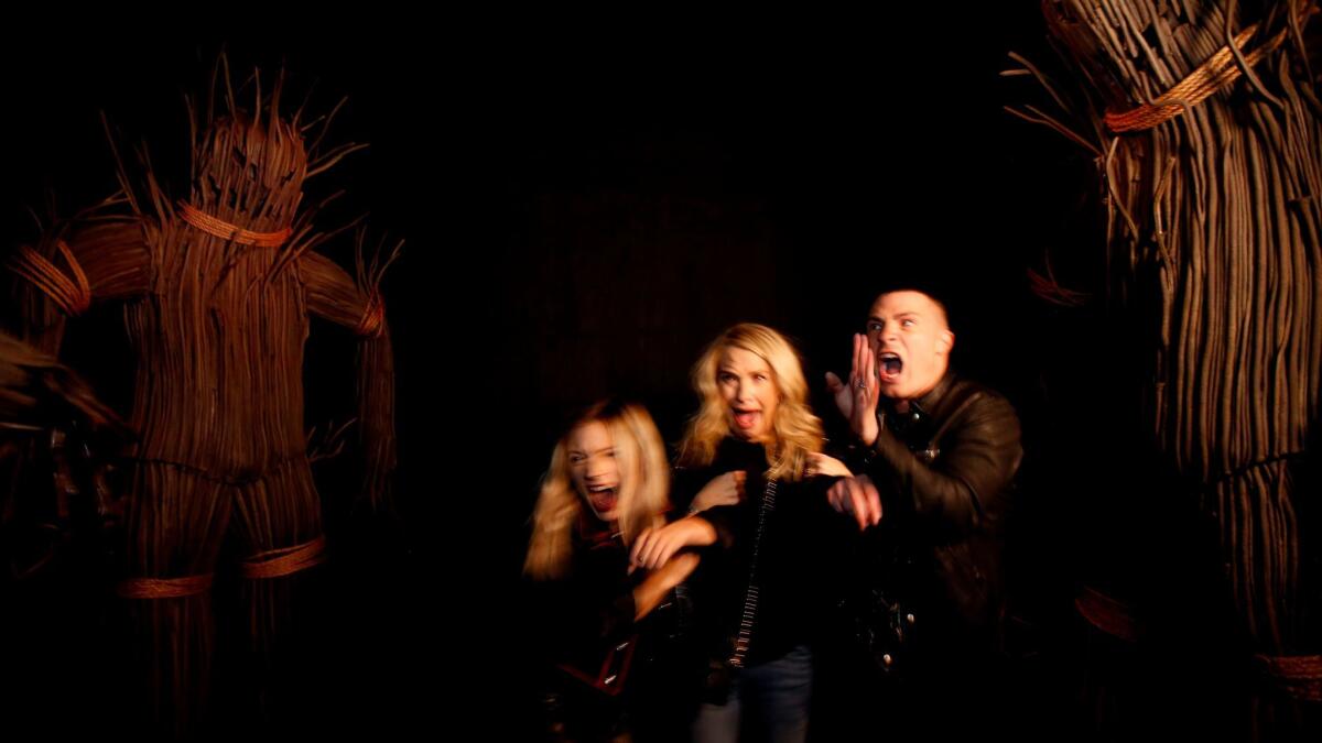"American Horror Story" actors Billie Lourd, left, Leslie Grossman and Colton Haynes react to a few of the surprises at the American Horror Story: Roanoke attraction at Universal Studios.