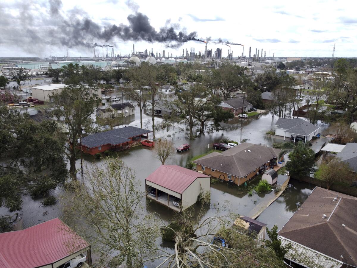 FILE - Homes near Norco, La., are surrounded by floodwater as chemical refineries continue to flare the day after Hurricane Ida hit southern Louisiana, Aug. 30, 2021. Environmental and climate justice advocates from across the United States are decrying the court's 6-3 ruling on Thursday, June 30, 2022, saying it will be felt most by communities of color and poor communities, which are located near power plants at higher percentages than the national average. (Chris Granger/The Times-Picayune/The New Orleans Advocate via AP, File)