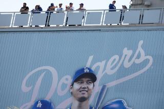 LOS ANGELES, CA - MARCH 28: Fans stand under a picture of Los Angeles Dodgers designated hitter Shohei Ohtani (17) in the stands before the game between the Los Angeles Dodgers and the St. Louis Cardinals in Dodgers Stadium on Thursday, March 28, 2024 in Los Angeles, CA. (Robert Gauthier / Los Angeles Times)