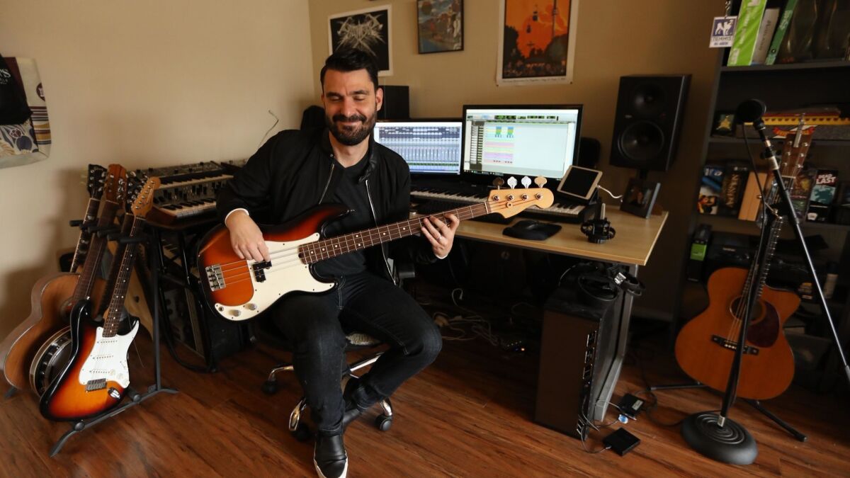 TV and film composer Ryan Elder plays his bass in the studio.