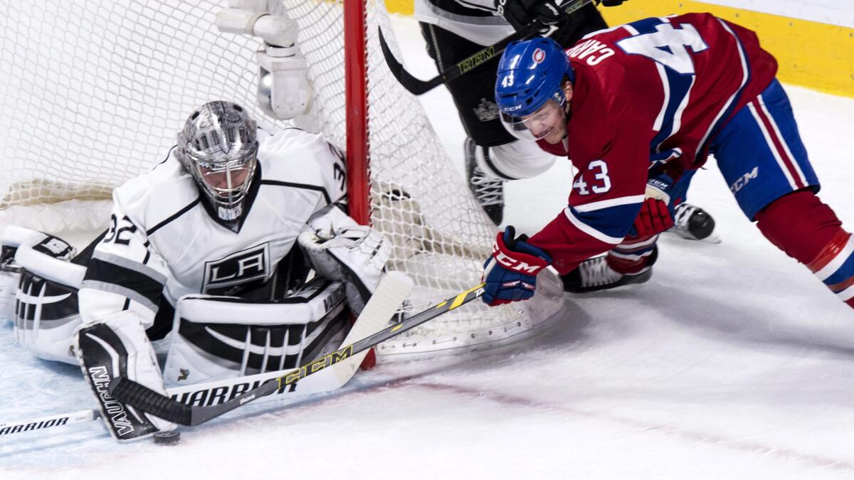 Kings goalie Jonathan Quick (32) stops Canadiens left wing Daniel Carr as he tries to score on a wrap-around shot in the second period Thursday night in Montreal.