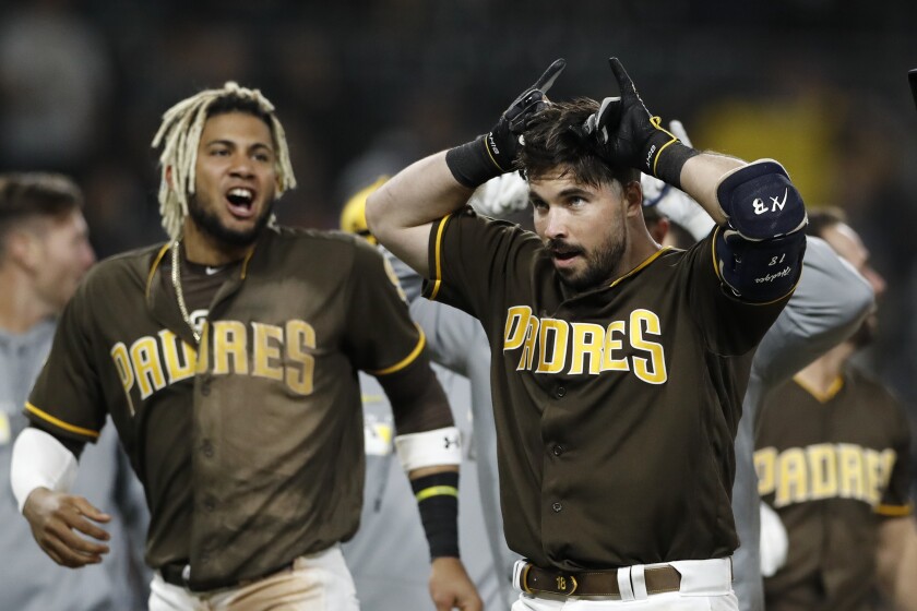 Austin Hedges, right, celebrates with Fernando Tatis Jr. and their Padres teammates after Hedges' walk-off single against the Nationals last June 7.