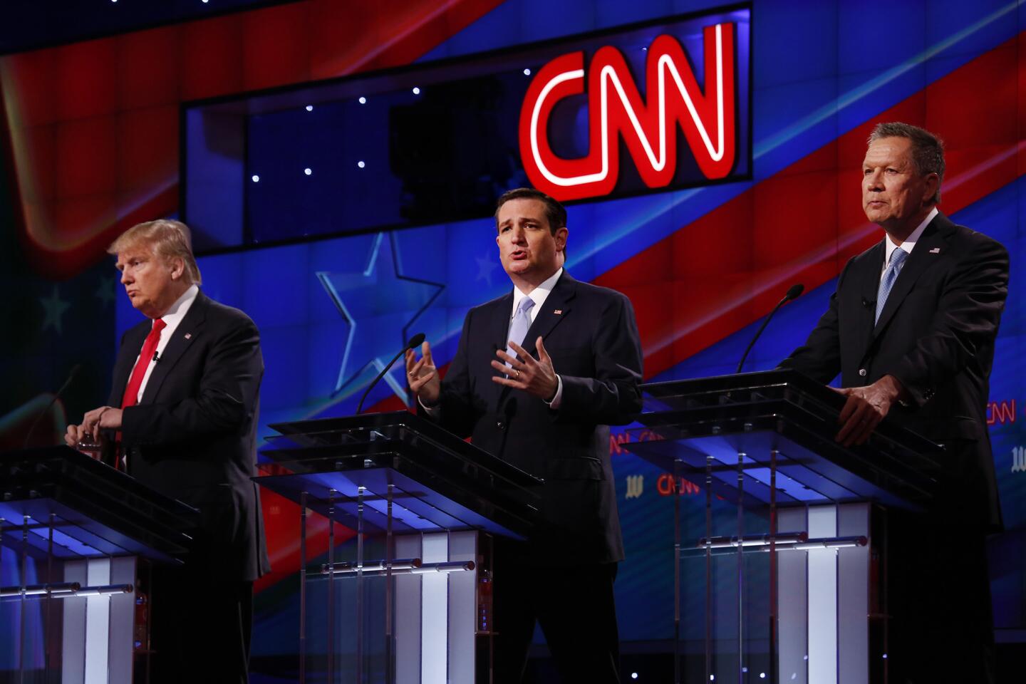 Ted Cruz, center, speaks as Donald Trump, left, and John Kasich listen during the debate at the University of Miami.