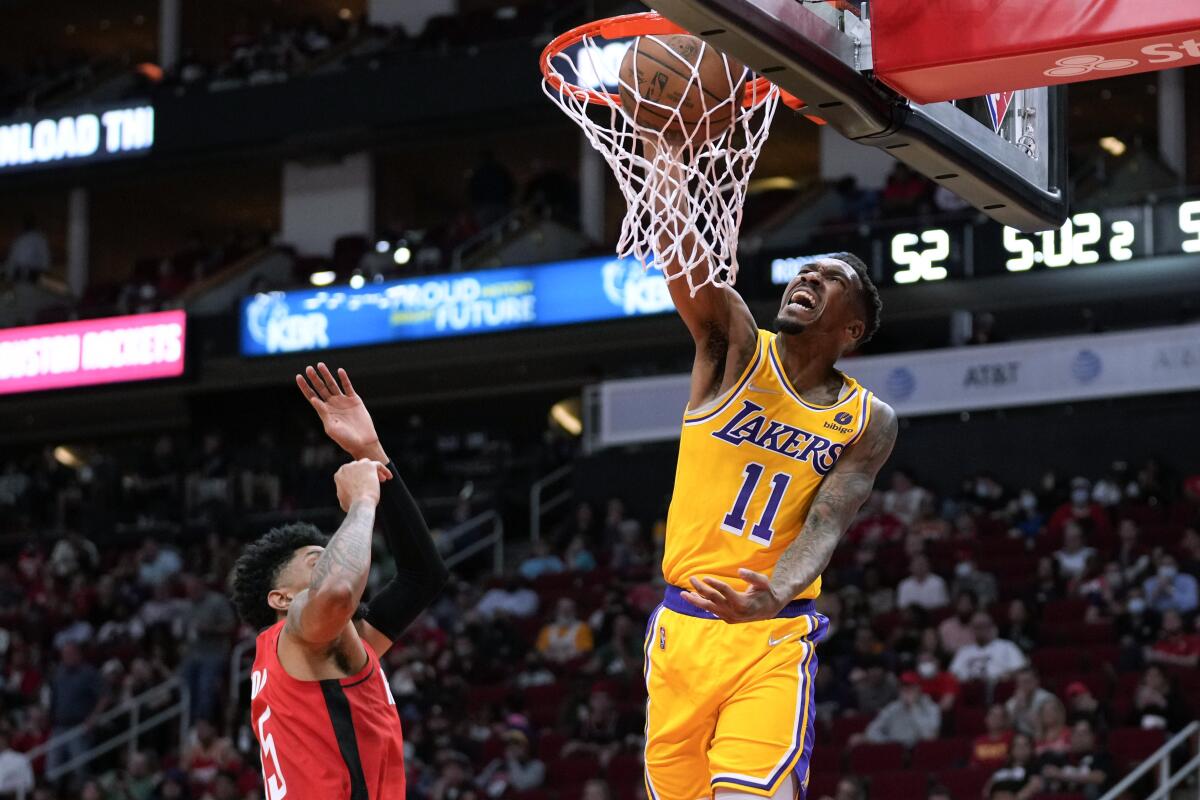 Lakers guard Malik Monk dunks next to Houston Rockets' Christian Wood.