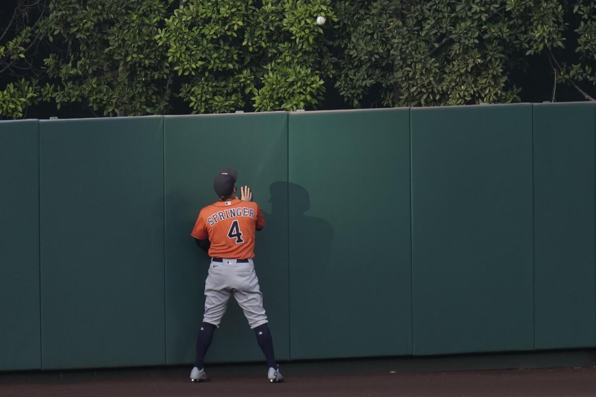 Astros center fielder George Springer watches a ball hit by the Angels' Mike Trout clear the wall Sept. 4, 2020.