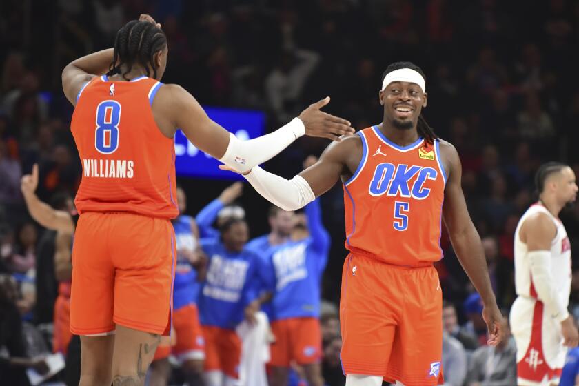 Luguentz Dort, base del Thunder de Oklahoma City, festeja con Jalen Williams, durante el partido ante los Rockets de Houston, el martes 27 de febrero de 2024 (AP Foto/Kyle Phillips)